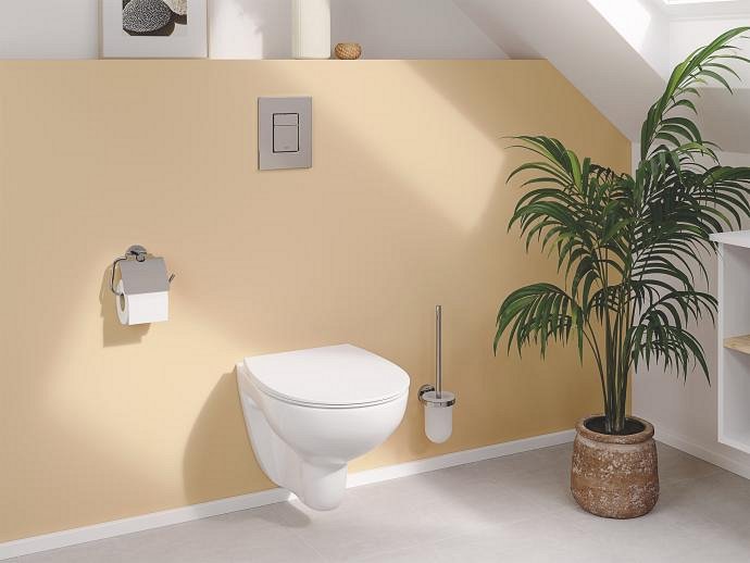 A SOLIDO wall-hung WC attached to a peach-coloured wall A SOLIDO wall-hung WC attached to a peach-coloured wall